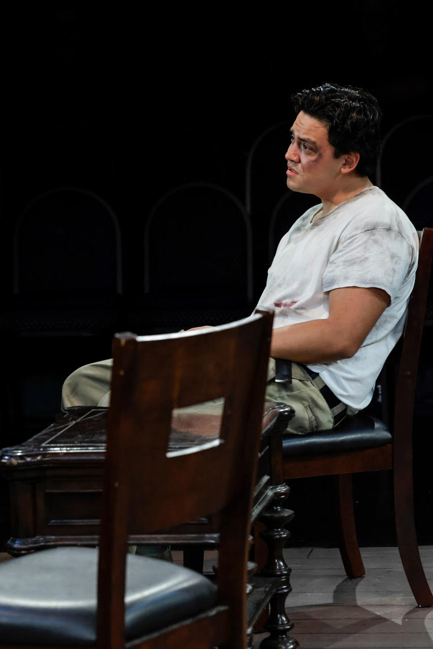 unnamed-2 Actor seated at a desk writing on documents during a scene from Kaddish for the Barrio.