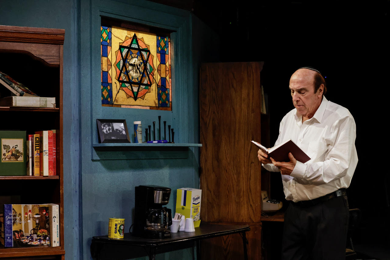 unnamed-3 Actor seated at a desk writing on documents during a scene from Kaddish for the Barrio.