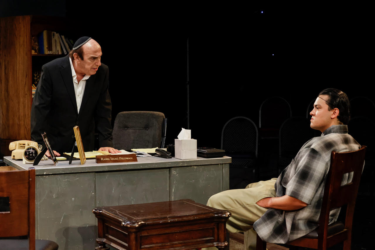 unnamed-4 Actor seated at a desk writing on documents during a scene from Kaddish for the Barrio.