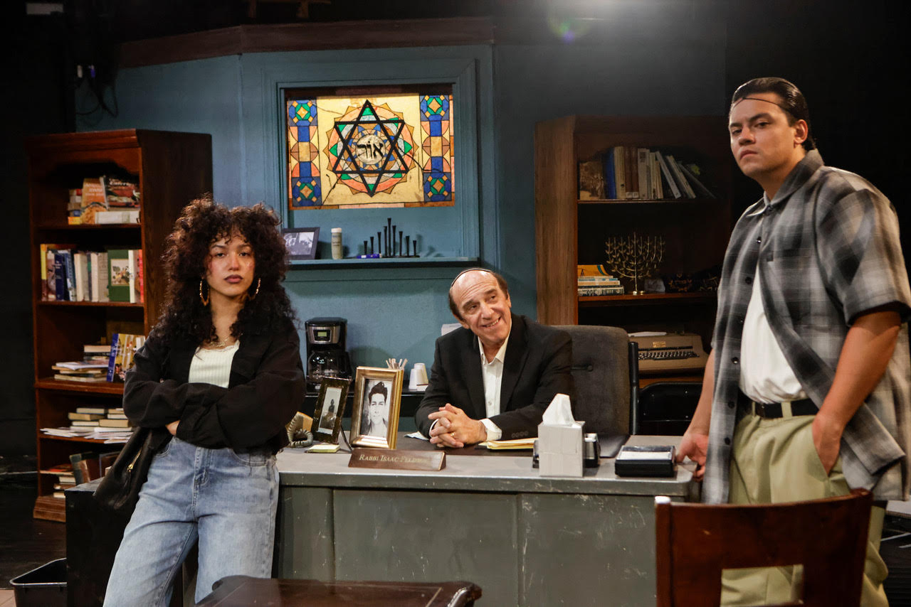 unnamed-8 Actor seated at a desk writing on documents during a scene from Kaddish for the Barrio.