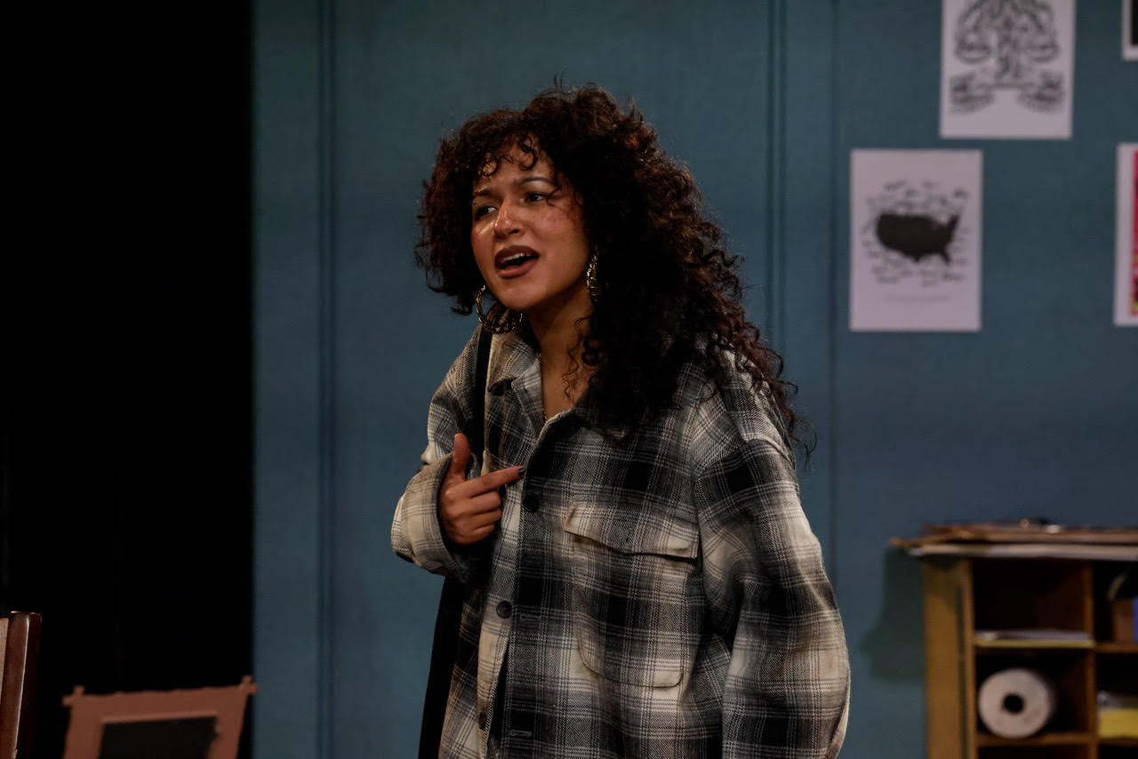 unnamed Actor seated at a desk writing on documents during a scene from Kaddish for the Barrio.